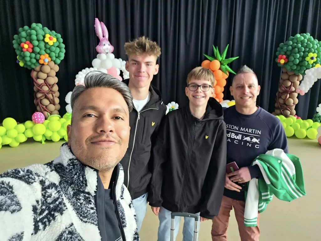 Rotterdam Cruise Port: Our Complete Guide + Insider Tips 2026 (Visited 5 Times Since 2022 by Danny and Peter) 16 Cruising with Danny and Peter, Holland America Line, Nieuw Statendam, Rotterdam, The Netherlands, Voyage Rotterdam Nieuw Statendam Embarkation | A vibrant collage capturing embarkation day on Holland America’s Nieuw Statendam docked at Rotterdam’s Cruise Terminal, with the Erasmus Bridge and Zalmhaventoren in the background under a golden afternoon sky. The ship’s elegant atrium sparkles with a chandelier, while a cozy Oceanview Family Cabin showcases bunk beds and large windows framing the Nieuwe Maas. A family tours the Lido Market, where tables overflow with herb-crusted lamb, chocolate eggs, and colorful desserts for Easter lunch. On deck, two teenagers snap selfies against Rotterdam’s twinkling skyline during sail away, the ship gliding past the illuminated Swan Bridge. In the Ocean Bar, friends toast with cocktails, and the Crow’s Nest lounge offers panoramic views of the river. The scene closes with a cozy cabin moment, a TV glowing with Formula 1 action, hot chocolate mugs on a table, and the gentle sway of the ship at dusk.