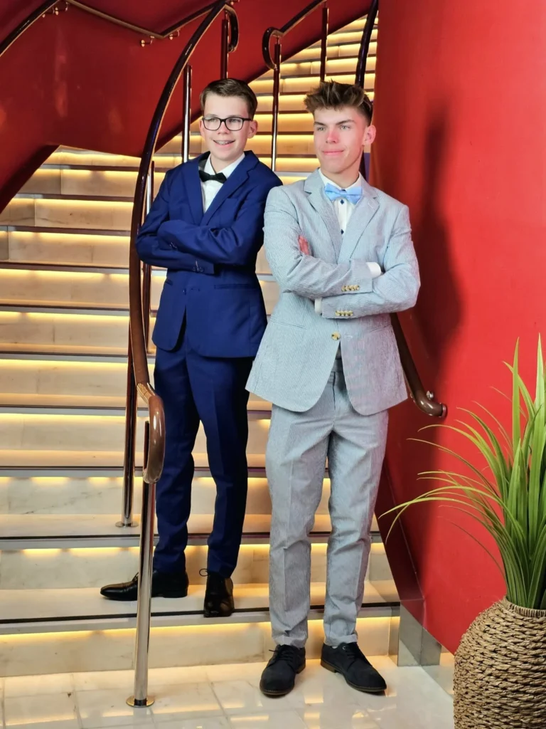 A Voyage Through Time and Tide: Exploring the English Channel Aboard Holland America Line’s Nieuw Statendam 19 Cruising with Danny and Peter, Holland America Line, Nieuw Statendam, English Channel, Sea Day, English Channel Nieuw Statendam Sea Day Experience | A luxurious scene aboard Holland America Line’s Nieuw Statendam cruising the English Channel, featuring the Main Dining Room with elegantly set tables, gourmet dishes like eggs Benedict, and large windows revealing gray-green waves; the intimate Pinnacle Grill with plush seating and a plated beef tenderloin with lobster dumplings; the World Stage theater’s circular stage and vibrant 270-degree LED screen displaying Casablanca’s Hassan II Mosque; and the ship’s sleek white hull sailing smoothly under an overcast sky, embodying modern cruising elegance.