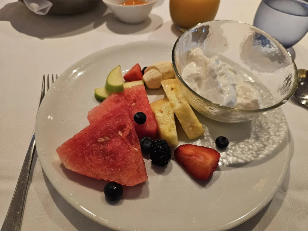 Cruising with Danny and Peter, Holland America Line, Nieuw Statendam, Atlantic Ocean Sea Day Experience | A vibrant collage capturing a sea day on Holland America’s Nieuw Statendam: a panoramic view of the Atlantic Ocean’s deep blue waves under golden sunlight from the ship’s deck; an elegant breakfast of eggs Benedict and coffee in the Main Dining Room with ocean-view windows; a digital iris collage with colorful, galaxy-like patterns created in the Explorations Central lounge; and a lively Cassidy Robertson & Company performance on the World Stage, featuring dancers in vibrant costumes against a futuristic LED backdrop.