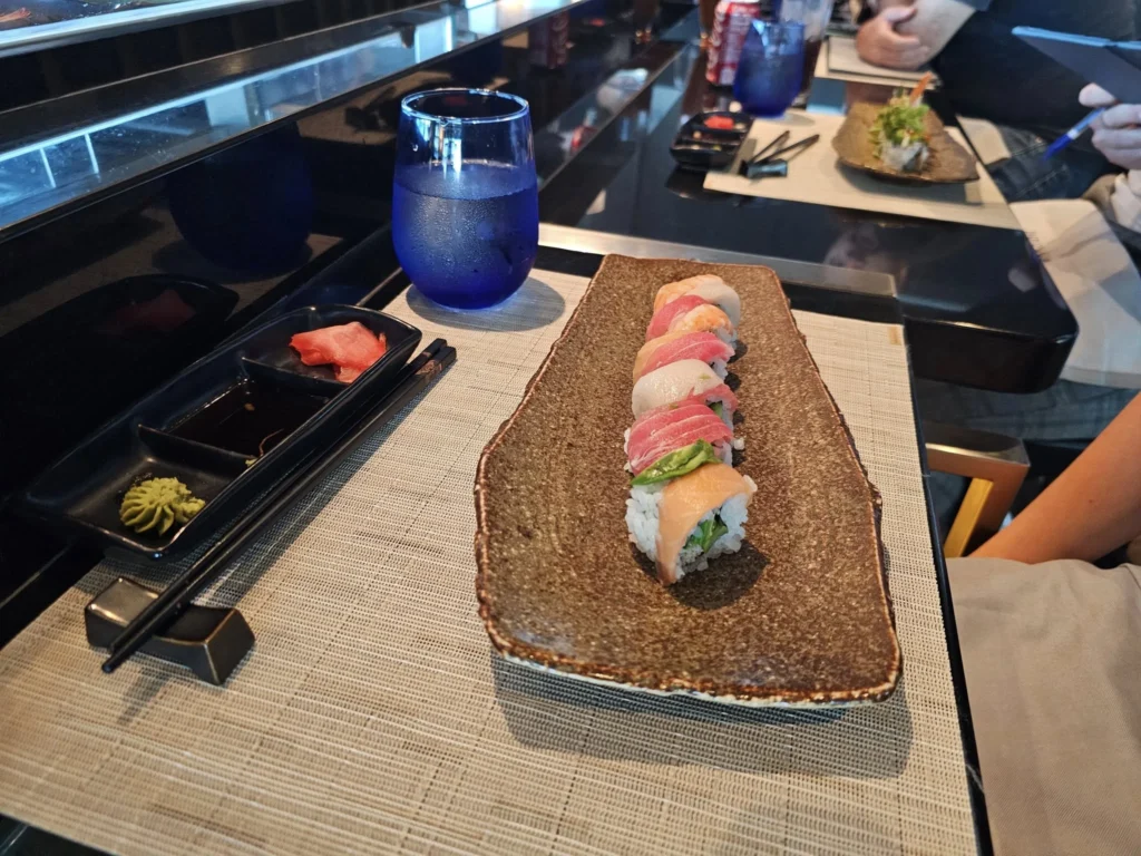 Cruising with Danny and Peter, Holland America Line, Nieuw Statendam, Atlantic Ocean Sea Day Experience | A vibrant collage capturing a sea day on Holland America’s Nieuw Statendam: a panoramic view of the Atlantic Ocean’s deep blue waves under golden sunlight from the ship’s deck; an elegant breakfast of eggs Benedict and coffee in the Main Dining Room with ocean-view windows; a digital iris collage with colorful, galaxy-like patterns created in the Explorations Central lounge; and a lively Cassidy Robertson & Company performance on the World Stage, featuring dancers in vibrant costumes against a futuristic LED backdrop.