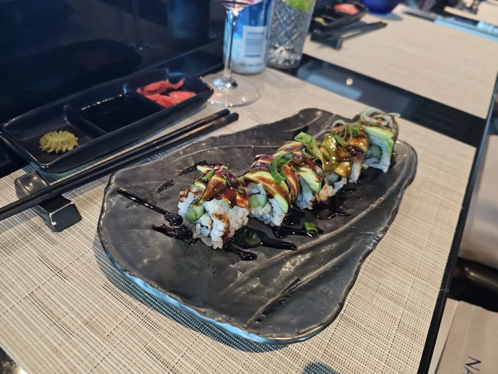 Cruising with Danny and Peter, Holland America Line, Nieuw Statendam, Atlantic Ocean Sea Day Experience | A vibrant collage capturing a sea day on Holland America’s Nieuw Statendam: a panoramic view of the Atlantic Ocean’s deep blue waves under golden sunlight from the ship’s deck; an elegant breakfast of eggs Benedict and coffee in the Main Dining Room with ocean-view windows; a digital iris collage with colorful, galaxy-like patterns created in the Explorations Central lounge; and a lively Cassidy Robertson & Company performance on the World Stage, featuring dancers in vibrant costumes against a futuristic LED backdrop.