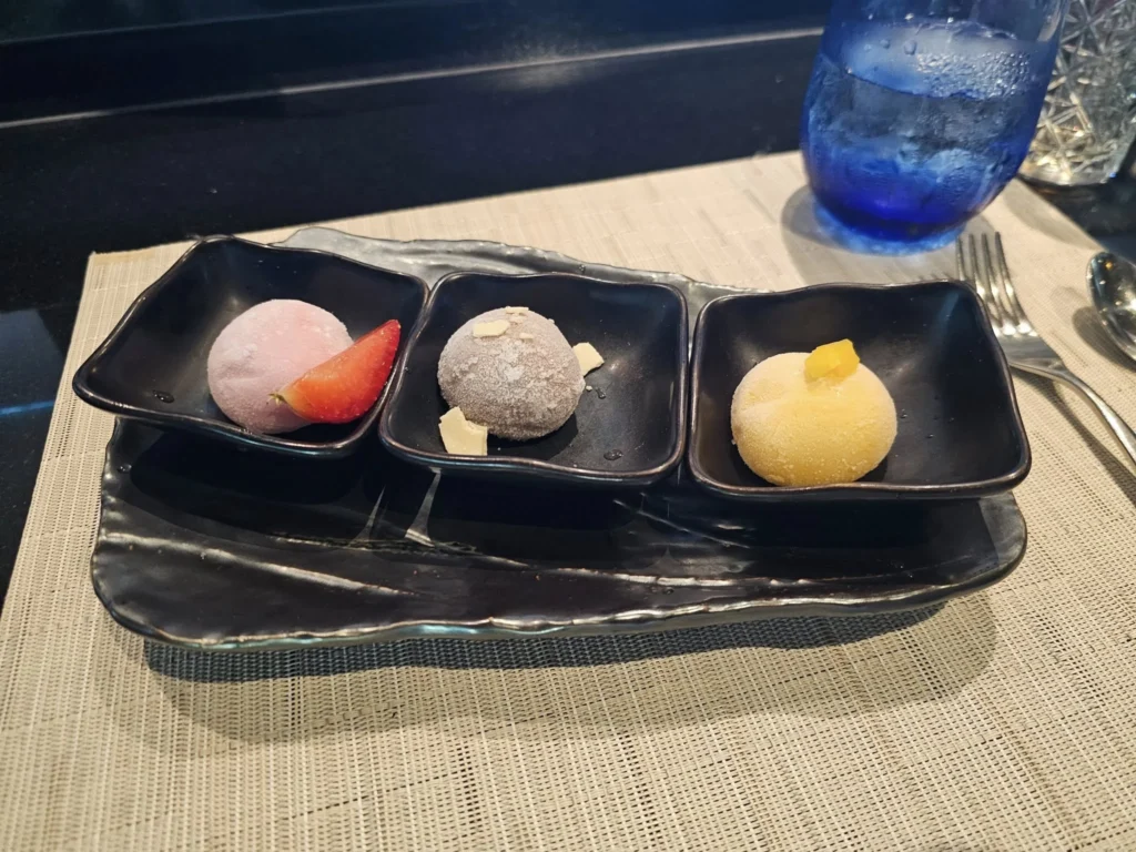 Cruising with Danny and Peter, Holland America Line, Nieuw Statendam, Atlantic Ocean Sea Day Experience | A vibrant collage capturing a sea day on Holland America’s Nieuw Statendam: a panoramic view of the Atlantic Ocean’s deep blue waves under golden sunlight from the ship’s deck; an elegant breakfast of eggs Benedict and coffee in the Main Dining Room with ocean-view windows; a digital iris collage with colorful, galaxy-like patterns created in the Explorations Central lounge; and a lively Cassidy Robertson & Company performance on the World Stage, featuring dancers in vibrant costumes against a futuristic LED backdrop.