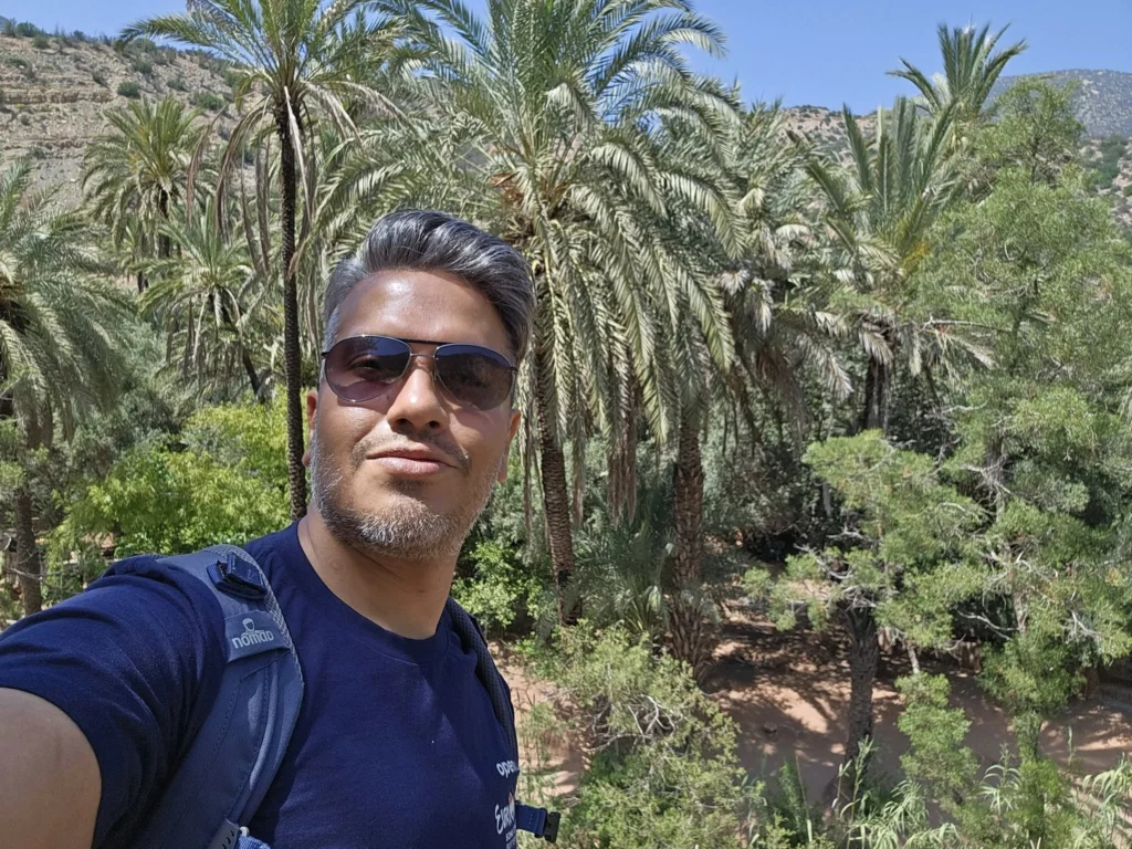 Cruising with Danny and Peter, Holland America Line, Nieuw Statendam, Agadir Morocco Adventure | A vibrant collage capturing a day in Agadir, Morocco, during a Holland America Nieuw Statendam cruise: the white façade and green-tiled minaret of Mosque Mohammed V gleaming under the sun; the bustling Agadir Marina with yachts bobbing in the harbor and golden beach sands stretching toward the Anti-Atlas Mountains; the historic Agadir Oufella kasbah ruins on a hill overlooking the sparkling Atlantic; Sven riding a camel along a scenic path with a Berber handler; the colorful chaos of Souk El Had market with stalls of spices, rugs, and jewelry; the lush Paradise Valley oasis with palm trees, clear pools, and tiny fish nibbling at feet; and an aromatic garden with Moroccan bread, argan oil, and mint tea under a shaded canopy.