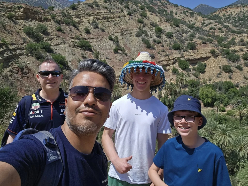 Cruising with Danny and Peter, Holland America Line, Nieuw Statendam, Agadir Morocco Adventure | A vibrant collage capturing a day in Agadir, Morocco, during a Holland America Nieuw Statendam cruise: the white façade and green-tiled minaret of Mosque Mohammed V gleaming under the sun; the bustling Agadir Marina with yachts bobbing in the harbor and golden beach sands stretching toward the Anti-Atlas Mountains; the historic Agadir Oufella kasbah ruins on a hill overlooking the sparkling Atlantic; Sven riding a camel along a scenic path with a Berber handler; the colorful chaos of Souk El Had market with stalls of spices, rugs, and jewelry; the lush Paradise Valley oasis with palm trees, clear pools, and tiny fish nibbling at feet; and an aromatic garden with Moroccan bread, argan oil, and mint tea under a shaded canopy.