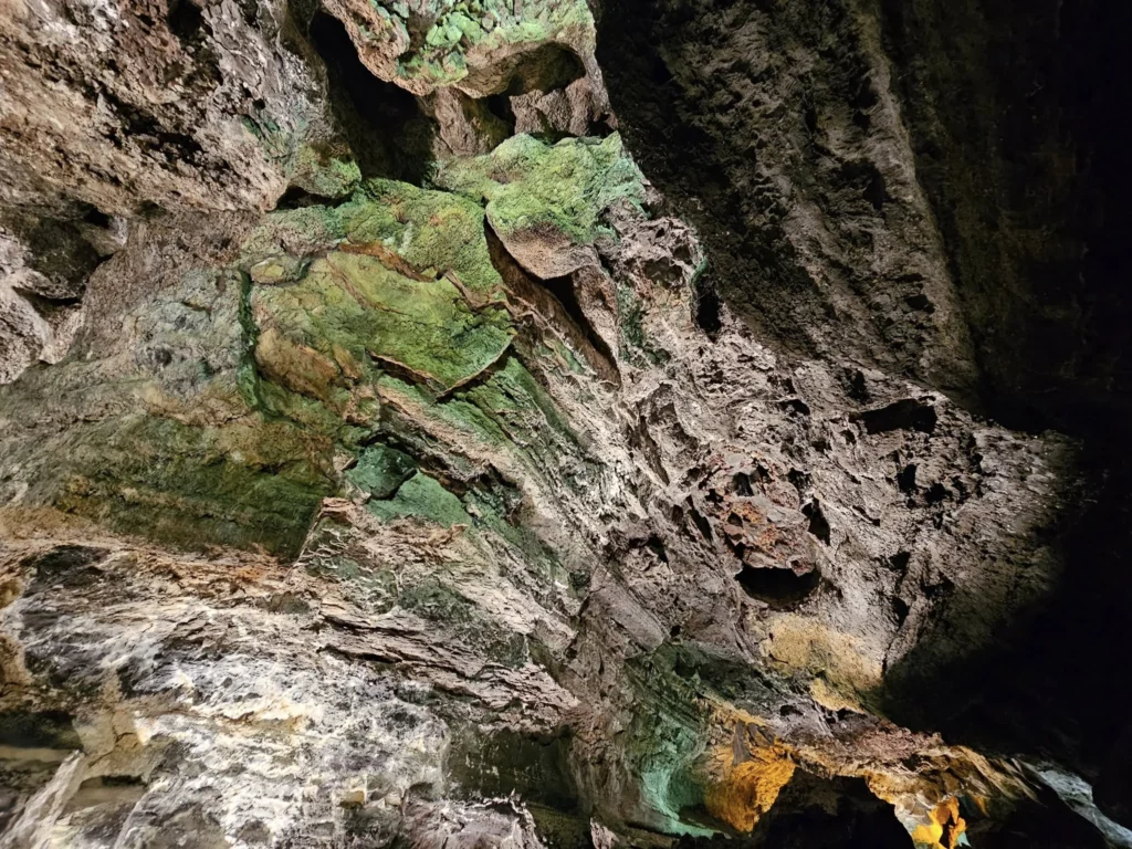 Cruising with Danny and Peter, Holland America Line, Nieuw Statendam, Arrecife, Lanzarote, Canary Islands, Volcanic Adventure | A vibrant collage capturing an adventure in Arrecife, Lanzarote: the dark, winding lava tunnels of Cueva de los Verdes illuminated by soft lights; the serene turquoise pool and lush greenery of Jameos del Agua with its volcanic cave backdrop; the sweeping ocean views from Mirador del Río’s cliffside lookout, framing La Graciosa island; and the surreal, Mars-like red and black lava fields of Timanfaya National Park under a clear sky, showcasing Lanzarote’s volcanic beauty.