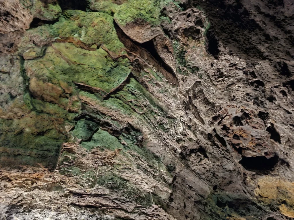 Cruising with Danny and Peter, Holland America Line, Nieuw Statendam, Arrecife, Lanzarote, Canary Islands, Volcanic Adventure | A vibrant collage capturing an adventure in Arrecife, Lanzarote: the dark, winding lava tunnels of Cueva de los Verdes illuminated by soft lights; the serene turquoise pool and lush greenery of Jameos del Agua with its volcanic cave backdrop; the sweeping ocean views from Mirador del Río’s cliffside lookout, framing La Graciosa island; and the surreal, Mars-like red and black lava fields of Timanfaya National Park under a clear sky, showcasing Lanzarote’s volcanic beauty.