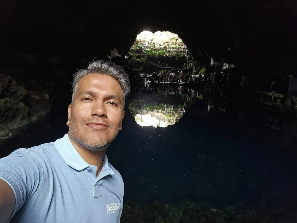 Cruising with Danny and Peter, Holland America Line, Nieuw Statendam, Arrecife, Lanzarote, Canary Islands, Volcanic Adventure | A vibrant collage capturing an adventure in Arrecife, Lanzarote: the dark, winding lava tunnels of Cueva de los Verdes illuminated by soft lights; the serene turquoise pool and lush greenery of Jameos del Agua with its volcanic cave backdrop; the sweeping ocean views from Mirador del Río’s cliffside lookout, framing La Graciosa island; and the surreal, Mars-like red and black lava fields of Timanfaya National Park under a clear sky, showcasing Lanzarote’s volcanic beauty.