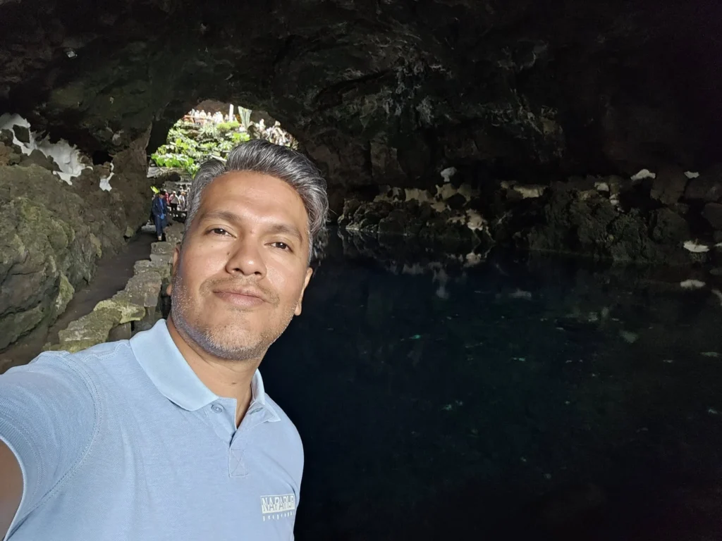 Cruising with Danny and Peter, Holland America Line, Nieuw Statendam, Arrecife, Lanzarote, Canary Islands, Volcanic Adventure | A vibrant collage capturing an adventure in Arrecife, Lanzarote: the dark, winding lava tunnels of Cueva de los Verdes illuminated by soft lights; the serene turquoise pool and lush greenery of Jameos del Agua with its volcanic cave backdrop; the sweeping ocean views from Mirador del Río’s cliffside lookout, framing La Graciosa island; and the surreal, Mars-like red and black lava fields of Timanfaya National Park under a clear sky, showcasing Lanzarote’s volcanic beauty.