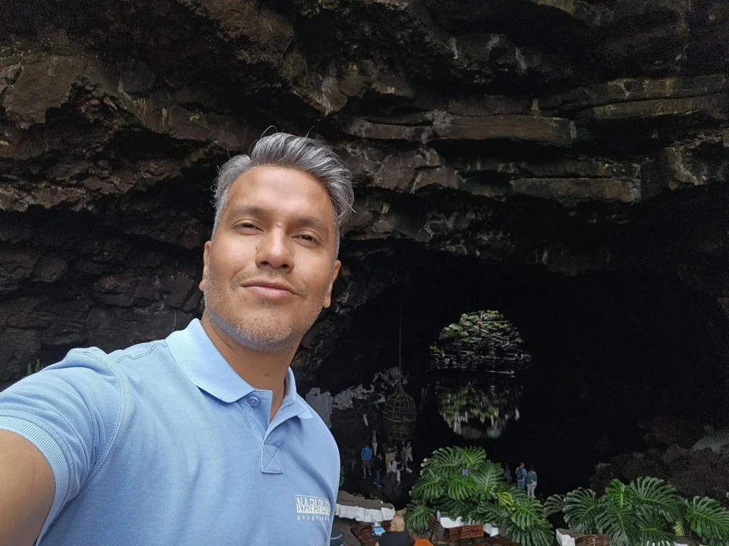 Cruising with Danny and Peter, Holland America Line, Nieuw Statendam, Arrecife, Lanzarote, Canary Islands, Volcanic Adventure | A vibrant collage capturing an adventure in Arrecife, Lanzarote: the dark, winding lava tunnels of Cueva de los Verdes illuminated by soft lights; the serene turquoise pool and lush greenery of Jameos del Agua with its volcanic cave backdrop; the sweeping ocean views from Mirador del Río’s cliffside lookout, framing La Graciosa island; and the surreal, Mars-like red and black lava fields of Timanfaya National Park under a clear sky, showcasing Lanzarote’s volcanic beauty.