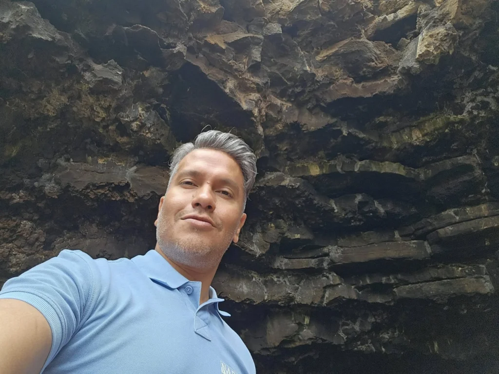 Cruising with Danny and Peter, Holland America Line, Nieuw Statendam, Arrecife, Lanzarote, Canary Islands, Volcanic Adventure | A vibrant collage capturing an adventure in Arrecife, Lanzarote: the dark, winding lava tunnels of Cueva de los Verdes illuminated by soft lights; the serene turquoise pool and lush greenery of Jameos del Agua with its volcanic cave backdrop; the sweeping ocean views from Mirador del Río’s cliffside lookout, framing La Graciosa island; and the surreal, Mars-like red and black lava fields of Timanfaya National Park under a clear sky, showcasing Lanzarote’s volcanic beauty.