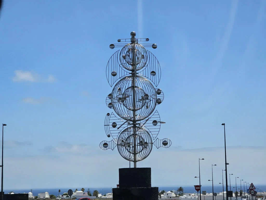 Cruising with Danny and Peter, Holland America Line, Nieuw Statendam, Arrecife, Lanzarote, Canary Islands, Volcanic Adventure | A vibrant collage capturing an adventure in Arrecife, Lanzarote: the dark, winding lava tunnels of Cueva de los Verdes illuminated by soft lights; the serene turquoise pool and lush greenery of Jameos del Agua with its volcanic cave backdrop; the sweeping ocean views from Mirador del Río’s cliffside lookout, framing La Graciosa island; and the surreal, Mars-like red and black lava fields of Timanfaya National Park under a clear sky, showcasing Lanzarote’s volcanic beauty.