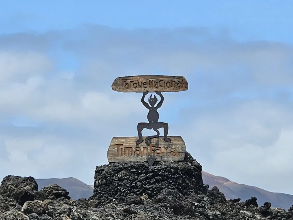 Cruising with Danny and Peter, Holland America Line, Nieuw Statendam, Arrecife, Lanzarote, Canary Islands, Volcanic Adventure | A vibrant collage capturing an adventure in Arrecife, Lanzarote: the dark, winding lava tunnels of Cueva de los Verdes illuminated by soft lights; the serene turquoise pool and lush greenery of Jameos del Agua with its volcanic cave backdrop; the sweeping ocean views from Mirador del Río’s cliffside lookout, framing La Graciosa island; and the surreal, Mars-like red and black lava fields of Timanfaya National Park under a clear sky, showcasing Lanzarote’s volcanic beauty.