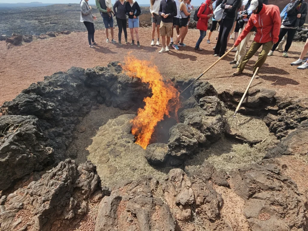 Cruising with Danny and Peter, Holland America Line, Nieuw Statendam, Arrecife, Lanzarote, Canary Islands, Volcanic Adventure | A vibrant collage capturing an adventure in Arrecife, Lanzarote: the dark, winding lava tunnels of Cueva de los Verdes illuminated by soft lights; the serene turquoise pool and lush greenery of Jameos del Agua with its volcanic cave backdrop; the sweeping ocean views from Mirador del Río’s cliffside lookout, framing La Graciosa island; and the surreal, Mars-like red and black lava fields of Timanfaya National Park under a clear sky, showcasing Lanzarote’s volcanic beauty.