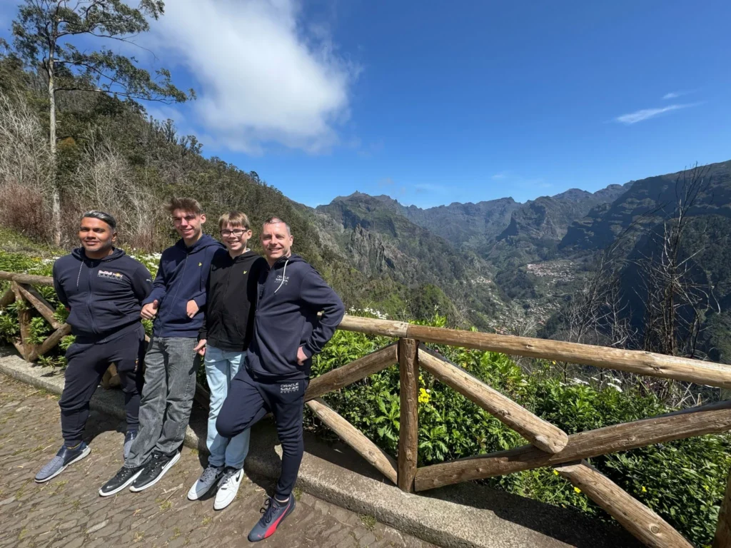 Cruising with Danny and Peter, Holland America Line, Nieuw Statendam, Funchal, Madeira. Portugal, History Adventure | A vibrant collage capturing a day in Funchal, Madeira: a sleek trike navigates winding roads with lush green hills in the background; the panoramic view from Pico dos Barcelos showcases Funchal Bay and the Desertas Islands under a clear sky; Cascata dos Anjos waterfall cascades from cliffs onto a road, surrounded by verdant greenery; Praia da Madalena do Mar’s pebbled beach and black volcanic sand meet gentle waves with towering cliffs above; the misty Valley of the Nuns nestles between rugged mountains, dotted with stone houses and chestnut groves; Cabo Girão’s glass-bottomed skywalk reveals a dizzying drop to the Atlantic and terraced fields below; a plate of warm bolo do caco flatbread filled with steak sits on a café table in Funchal’s colorful old town; the CR7 Museum displays Cristiano Ronaldo’s trophies and jerseys with a waterfront view of the Nieuw Statendam; and Nami Sushi Bar’s elegant sushi platter gleams under soft lighting aboard the ship.