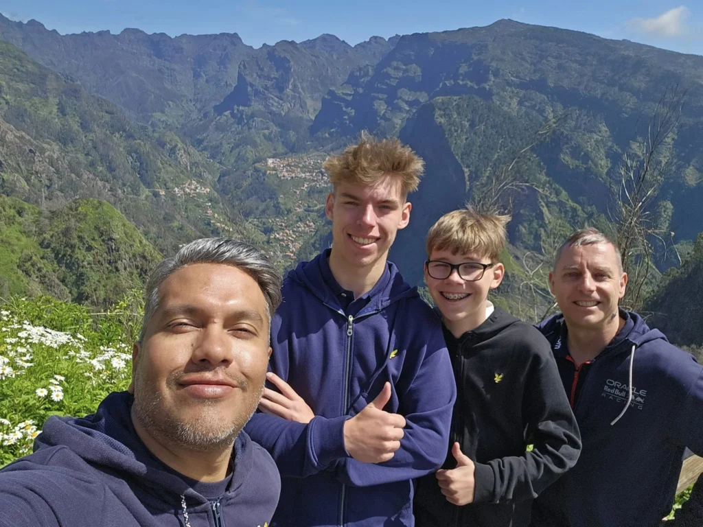 Cruising with Danny and Peter, Holland America Line, Nieuw Statendam, Funchal, Madeira. Portugal, History Adventure | A vibrant collage capturing a day in Funchal, Madeira: a sleek trike navigates winding roads with lush green hills in the background; the panoramic view from Pico dos Barcelos showcases Funchal Bay and the Desertas Islands under a clear sky; Cascata dos Anjos waterfall cascades from cliffs onto a road, surrounded by verdant greenery; Praia da Madalena do Mar’s pebbled beach and black volcanic sand meet gentle waves with towering cliffs above; the misty Valley of the Nuns nestles between rugged mountains, dotted with stone houses and chestnut groves; Cabo Girão’s glass-bottomed skywalk reveals a dizzying drop to the Atlantic and terraced fields below; a plate of warm bolo do caco flatbread filled with steak sits on a café table in Funchal’s colorful old town; the CR7 Museum displays Cristiano Ronaldo’s trophies and jerseys with a waterfront view of the Nieuw Statendam; and Nami Sushi Bar’s elegant sushi platter gleams under soft lighting aboard the ship.
