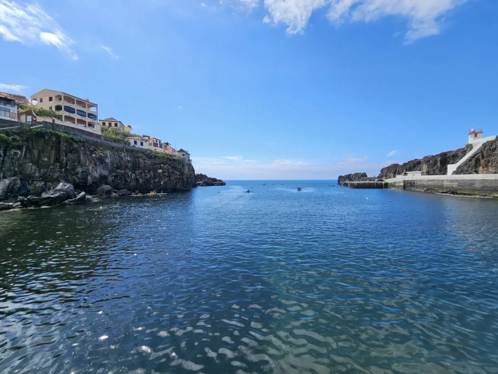 Cruising with Danny and Peter, Holland America Line, Nieuw Statendam, Funchal, Madeira. Portugal, History Adventure | A vibrant collage capturing a day in Funchal, Madeira: a sleek trike navigates winding roads with lush green hills in the background; the panoramic view from Pico dos Barcelos showcases Funchal Bay and the Desertas Islands under a clear sky; Cascata dos Anjos waterfall cascades from cliffs onto a road, surrounded by verdant greenery; Praia da Madalena do Mar’s pebbled beach and black volcanic sand meet gentle waves with towering cliffs above; the misty Valley of the Nuns nestles between rugged mountains, dotted with stone houses and chestnut groves; Cabo Girão’s glass-bottomed skywalk reveals a dizzying drop to the Atlantic and terraced fields below; a plate of warm bolo do caco flatbread filled with steak sits on a café table in Funchal’s colorful old town; the CR7 Museum displays Cristiano Ronaldo’s trophies and jerseys with a waterfront view of the Nieuw Statendam; and Nami Sushi Bar’s elegant sushi platter gleams under soft lighting aboard the ship.