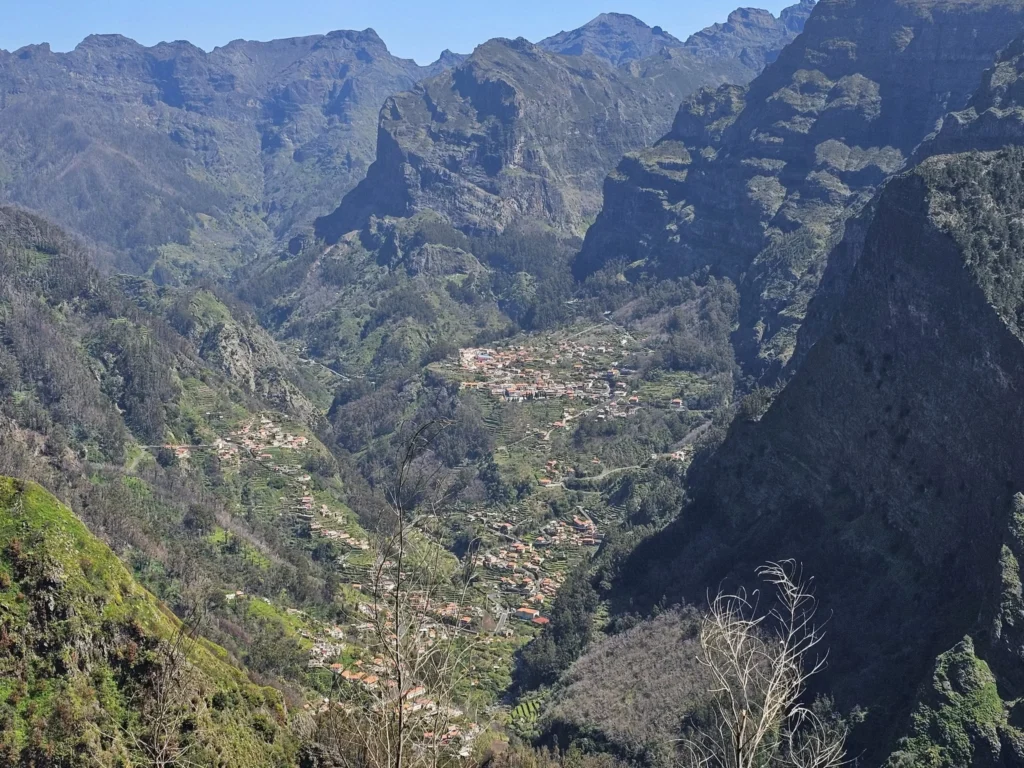 Cruising with Danny and Peter, Holland America Line, Nieuw Statendam, Funchal, Madeira. Portugal, History Adventure | A vibrant collage capturing a day in Funchal, Madeira: a sleek trike navigates winding roads with lush green hills in the background; the panoramic view from Pico dos Barcelos showcases Funchal Bay and the Desertas Islands under a clear sky; Cascata dos Anjos waterfall cascades from cliffs onto a road, surrounded by verdant greenery; Praia da Madalena do Mar’s pebbled beach and black volcanic sand meet gentle waves with towering cliffs above; the misty Valley of the Nuns nestles between rugged mountains, dotted with stone houses and chestnut groves; Cabo Girão’s glass-bottomed skywalk reveals a dizzying drop to the Atlantic and terraced fields below; a plate of warm bolo do caco flatbread filled with steak sits on a café table in Funchal’s colorful old town; the CR7 Museum displays Cristiano Ronaldo’s trophies and jerseys with a waterfront view of the Nieuw Statendam; and Nami Sushi Bar’s elegant sushi platter gleams under soft lighting aboard the ship.