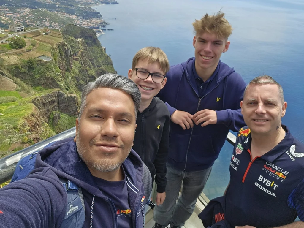 Cruising with Danny and Peter, Holland America Line, Nieuw Statendam, Funchal, Madeira. Portugal, History Adventure | A vibrant collage capturing a day in Funchal, Madeira: a sleek trike navigates winding roads with lush green hills in the background; the panoramic view from Pico dos Barcelos showcases Funchal Bay and the Desertas Islands under a clear sky; Cascata dos Anjos waterfall cascades from cliffs onto a road, surrounded by verdant greenery; Praia da Madalena do Mar’s pebbled beach and black volcanic sand meet gentle waves with towering cliffs above; the misty Valley of the Nuns nestles between rugged mountains, dotted with stone houses and chestnut groves; Cabo Girão’s glass-bottomed skywalk reveals a dizzying drop to the Atlantic and terraced fields below; a plate of warm bolo do caco flatbread filled with steak sits on a café table in Funchal’s colorful old town; the CR7 Museum displays Cristiano Ronaldo’s trophies and jerseys with a waterfront view of the Nieuw Statendam; and Nami Sushi Bar’s elegant sushi platter gleams under soft lighting aboard the ship.