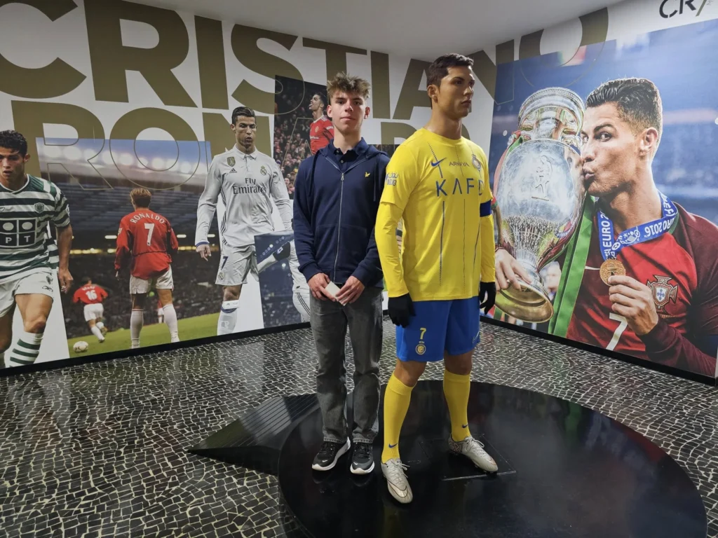 Cruising with Danny and Peter, Holland America Line, Nieuw Statendam, Funchal, Madeira. Portugal, History Adventure | A vibrant collage capturing a day in Funchal, Madeira: a sleek trike navigates winding roads with lush green hills in the background; the panoramic view from Pico dos Barcelos showcases Funchal Bay and the Desertas Islands under a clear sky; Cascata dos Anjos waterfall cascades from cliffs onto a road, surrounded by verdant greenery; Praia da Madalena do Mar’s pebbled beach and black volcanic sand meet gentle waves with towering cliffs above; the misty Valley of the Nuns nestles between rugged mountains, dotted with stone houses and chestnut groves; Cabo Girão’s glass-bottomed skywalk reveals a dizzying drop to the Atlantic and terraced fields below; a plate of warm bolo do caco flatbread filled with steak sits on a café table in Funchal’s colorful old town; the CR7 Museum displays Cristiano Ronaldo’s trophies and jerseys with a waterfront view of the Nieuw Statendam; and Nami Sushi Bar’s elegant sushi platter gleams under soft lighting aboard the ship.