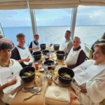 Cruising with Danny and Peter, Holland America Line, Nieuw Statendam, Atlantic Ocean, Sea Day, Adventure | A family savors a Nieuw Statendam Sea Day, enjoying a breakfast of cheesy omelets in the elegant main dining room, indulging in sushi rolls at the vibrant Lido Market, and feasting on a seafood boil with crab legs under starlit skies. The Atlantic Ocean sparkles outside, enhancing Holland America’s luxurious cruise experience with gourmet dining and relaxation.