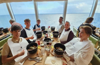 Cruising with Danny and Peter, Holland America Line, Nieuw Statendam, Atlantic Ocean, Sea Day, Adventure | A family savors a Nieuw Statendam Sea Day, enjoying a breakfast of cheesy omelets in the elegant main dining room, indulging in sushi rolls at the vibrant Lido Market, and feasting on a seafood boil with crab legs under starlit skies. The Atlantic Ocean sparkles outside, enhancing Holland America’s luxurious cruise experience with gourmet dining and relaxation.