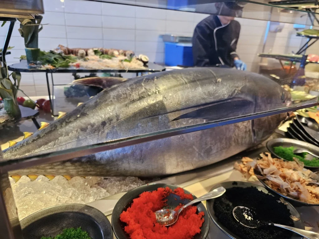 Cruising with Danny and Peter, Holland America Line, Nieuw Statendam, Atlantic Ocean, Sea Day, Adventure | A family savors a Nieuw Statendam Sea Day, enjoying a breakfast of cheesy omelets in the elegant main dining room, indulging in sushi rolls at the vibrant Lido Market, and feasting on a seafood boil with crab legs under starlit skies. The Atlantic Ocean sparkles outside, enhancing Holland America’s luxurious cruise experience with gourmet dining and relaxation.