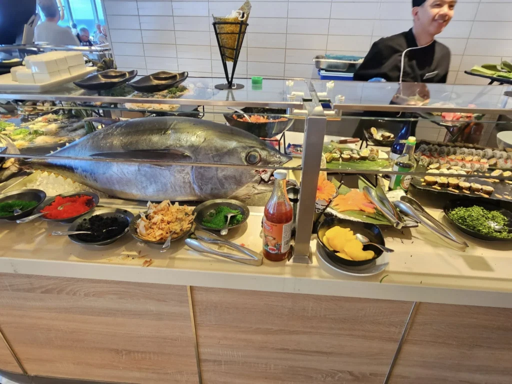 Cruising with Danny and Peter, Holland America Line, Nieuw Statendam, Atlantic Ocean, Sea Day, Adventure | A family savors a Nieuw Statendam Sea Day, enjoying a breakfast of cheesy omelets in the elegant main dining room, indulging in sushi rolls at the vibrant Lido Market, and feasting on a seafood boil with crab legs under starlit skies. The Atlantic Ocean sparkles outside, enhancing Holland America’s luxurious cruise experience with gourmet dining and relaxation.