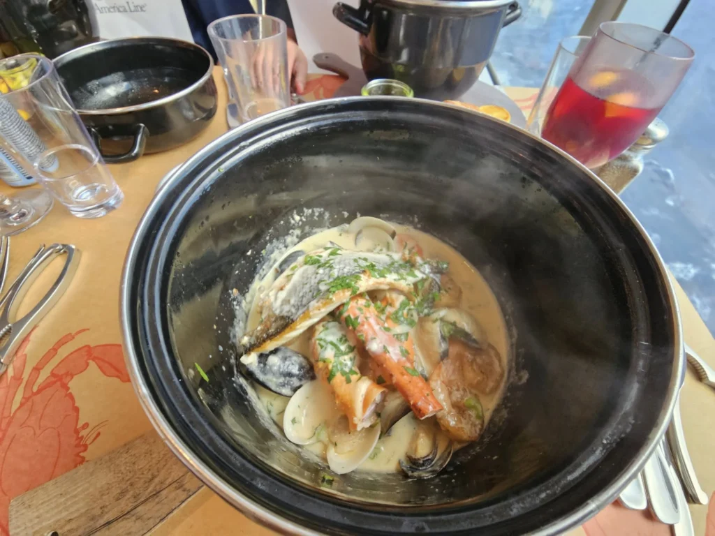 Cruising with Danny and Peter, Holland America Line, Nieuw Statendam, Atlantic Ocean, Sea Day, Adventure | A family savors a Nieuw Statendam Sea Day, enjoying a breakfast of cheesy omelets in the elegant main dining room, indulging in sushi rolls at the vibrant Lido Market, and feasting on a seafood boil with crab legs under starlit skies. The Atlantic Ocean sparkles outside, enhancing Holland America’s luxurious cruise experience with gourmet dining and relaxation.