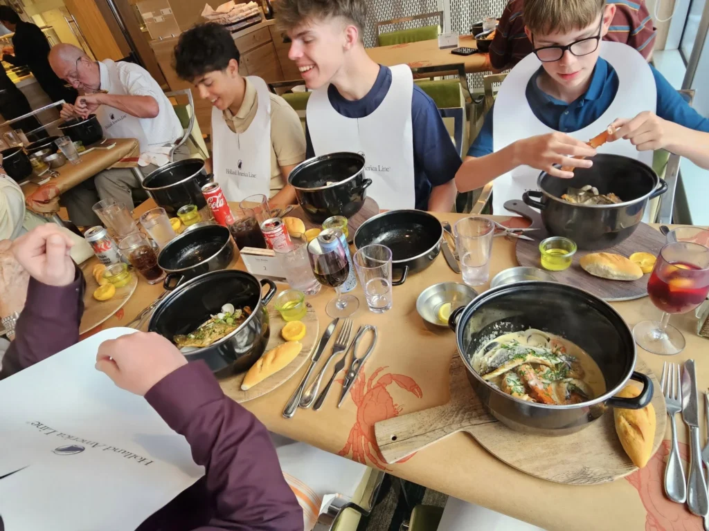 Cruising with Danny and Peter, Holland America Line, Nieuw Statendam, Atlantic Ocean, Sea Day, Adventure | A family savors a Nieuw Statendam Sea Day, enjoying a breakfast of cheesy omelets in the elegant main dining room, indulging in sushi rolls at the vibrant Lido Market, and feasting on a seafood boil with crab legs under starlit skies. The Atlantic Ocean sparkles outside, enhancing Holland America’s luxurious cruise experience with gourmet dining and relaxation.