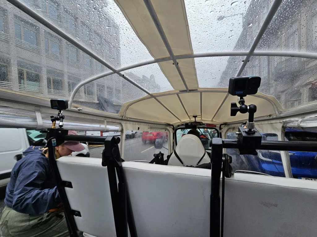 Cruising with Danny and Peter, Holland America Line, Nieuw Statendam, Leixoes, Porto, Portugal, Rainy Adventure | A vibrant collage capturing a rainy day adventure in Porto, Portugal, from the Holland America Line’s Nieuw Statendam cruise. The scene includes a colorful tuk-tuk navigating Porto’s wet, cobblestone streets with historic buildings in the background, the iconic Dom Luís I Bridge spanning the Douro River under gray skies, the majestic Porto Cathedral with its Gothic facade glistening in the rain, and the intricate blue-and-white azulejo tiles of São Bento Station’s atrium. Onboard, a beautifully plated dish from Tamarind restaurant showcases exotic flavors, while the lively Lido Fun Fair on the Lido Midship deck features children enjoying carnival games under a retractable roof, with colorful decorations and cotton candy adding festive cheer.