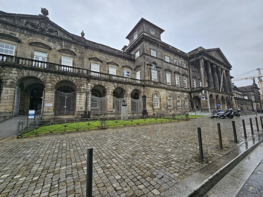 Cruising with Danny and Peter, Holland America Line, Nieuw Statendam, Leixoes, Porto, Portugal, Rainy Adventure | A vibrant collage capturing a rainy day adventure in Porto, Portugal, from the Holland America Line’s Nieuw Statendam cruise. The scene includes a colorful tuk-tuk navigating Porto’s wet, cobblestone streets with historic buildings in the background, the iconic Dom Luís I Bridge spanning the Douro River under gray skies, the majestic Porto Cathedral with its Gothic facade glistening in the rain, and the intricate blue-and-white azulejo tiles of São Bento Station’s atrium. Onboard, a beautifully plated dish from Tamarind restaurant showcases exotic flavors, while the lively Lido Fun Fair on the Lido Midship deck features children enjoying carnival games under a retractable roof, with colorful decorations and cotton candy adding festive cheer.