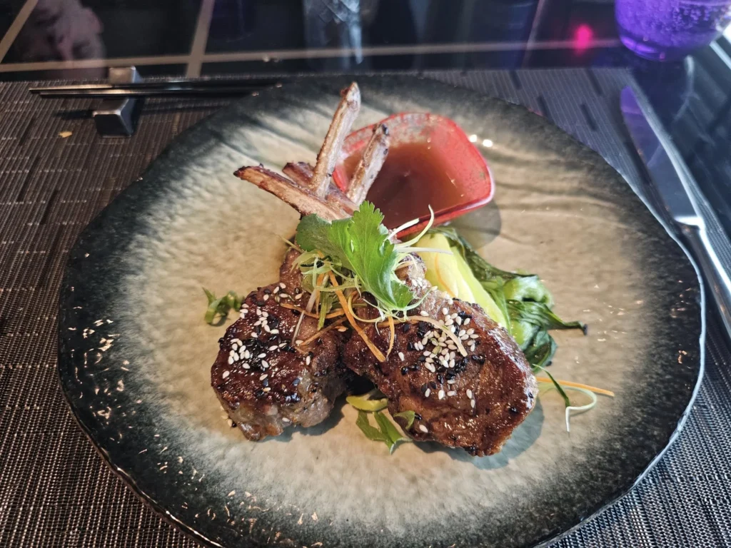 Cruising with Danny and Peter, Holland America Line, Nieuw Statendam, Leixoes, Porto, Portugal, Rainy Adventure | A vibrant collage capturing a rainy day adventure in Porto, Portugal, from the Holland America Line’s Nieuw Statendam cruise. The scene includes a colorful tuk-tuk navigating Porto’s wet, cobblestone streets with historic buildings in the background, the iconic Dom Luís I Bridge spanning the Douro River under gray skies, the majestic Porto Cathedral with its Gothic facade glistening in the rain, and the intricate blue-and-white azulejo tiles of São Bento Station’s atrium. Onboard, a beautifully plated dish from Tamarind restaurant showcases exotic flavors, while the lively Lido Fun Fair on the Lido Midship deck features children enjoying carnival games under a retractable roof, with colorful decorations and cotton candy adding festive cheer.