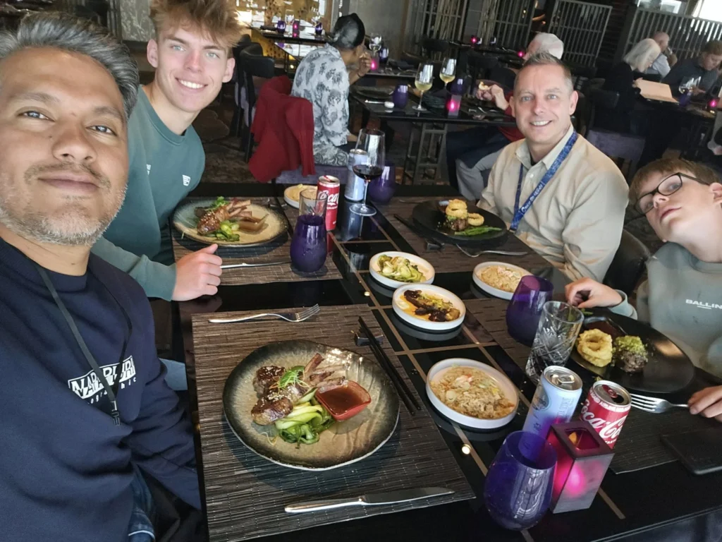 Cruising with Danny and Peter, Holland America Line, Nieuw Statendam, Leixoes, Porto, Portugal, Rainy Adventure | A vibrant collage capturing a rainy day adventure in Porto, Portugal, from the Holland America Line’s Nieuw Statendam cruise. The scene includes a colorful tuk-tuk navigating Porto’s wet, cobblestone streets with historic buildings in the background, the iconic Dom Luís I Bridge spanning the Douro River under gray skies, the majestic Porto Cathedral with its Gothic facade glistening in the rain, and the intricate blue-and-white azulejo tiles of São Bento Station’s atrium. Onboard, a beautifully plated dish from Tamarind restaurant showcases exotic flavors, while the lively Lido Fun Fair on the Lido Midship deck features children enjoying carnival games under a retractable roof, with colorful decorations and cotton candy adding festive cheer.