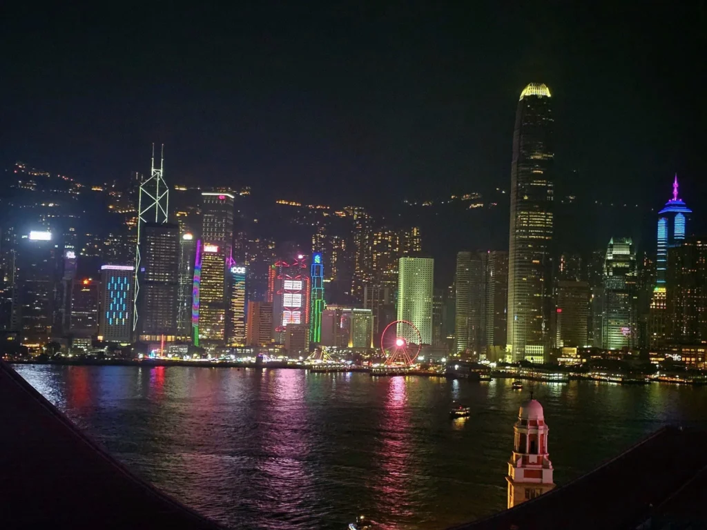 Cruising with Danny and Peter, Holland America Line, Westerdam, Hong Kong, China, Hong Kong Travel Guide: 10 Irresistible Gems | Panoramic Hong Kong Skyline Views from Sky100 Observation Deck showcasing Victoria Harbour and glittering skyscrapers at dusk, paired with a vibrant Temple Street Market scene featuring colorful stalls offering Hong Kong Street Food like dim sum, egg tarts, wonton noodles, and crispy fish balls in a bustling Hong Kong Night Markets atmosphere, alongside a scenic Tsim Sha Tsui Promenade view of Victoria Harbour with illuminated Hong Kong Skyline Views perfect for Hong Kong Tourism evenings, and the Holland America Line’s Westerdam docked in Hong Kong, marking the end of a Cruise Travel Hong Kong journey with Hong Kong Attractions in the background.