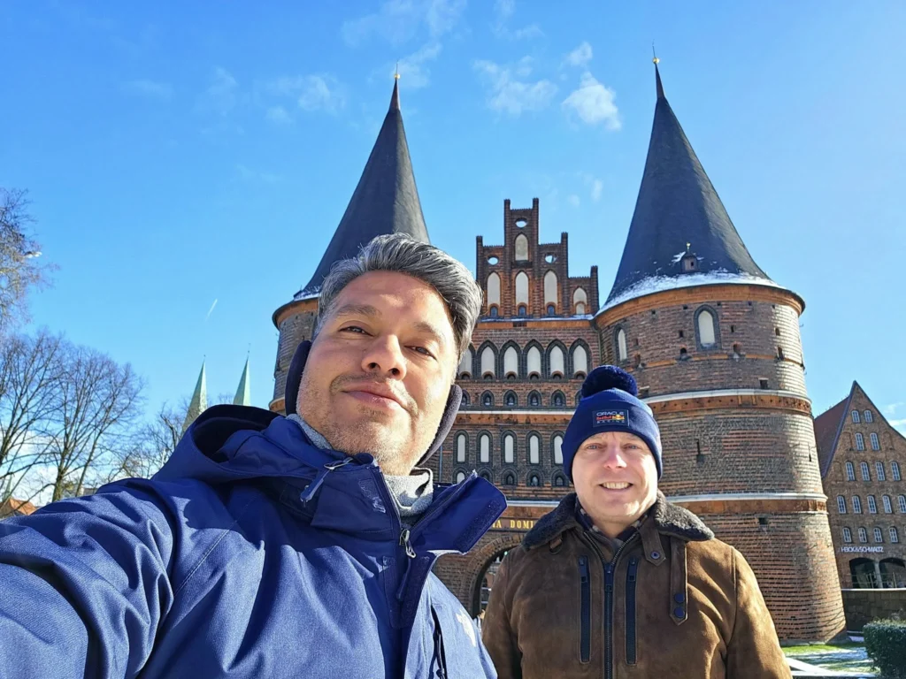 Cruising with Danny and Peter, MSC Cruises, MSC Preziosa, Hamburg, Germany, Lubeck City Tour showcasing the Holsten Gate, a historic medieval landmark with iconic round towers; St. Mary’s Church, known for its Gothic architecture and the world’s largest mechanical organ; charming cobblestone streets and UNESCO Heritage sites of Lubeck, reflecting its Hanseatic League history; traditional German lunch featuring bratwurst, sauerkraut, pretzels, and Lubeck’s famous marzipan, offering a taste of the city’s cultural and culinary heritage.