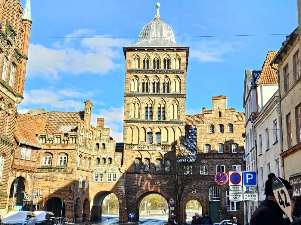 Cruising with Danny and Peter, MSC Cruises, MSC Preziosa, Hamburg, Germany, Lubeck City Tour showcasing the Holsten Gate, a historic medieval landmark with iconic round towers; St. Mary’s Church, known for its Gothic architecture and the world’s largest mechanical organ; charming cobblestone streets and UNESCO Heritage sites of Lubeck, reflecting its Hanseatic League history; traditional German lunch featuring bratwurst, sauerkraut, pretzels, and Lubeck’s famous marzipan, offering a taste of the city’s cultural and culinary heritage.