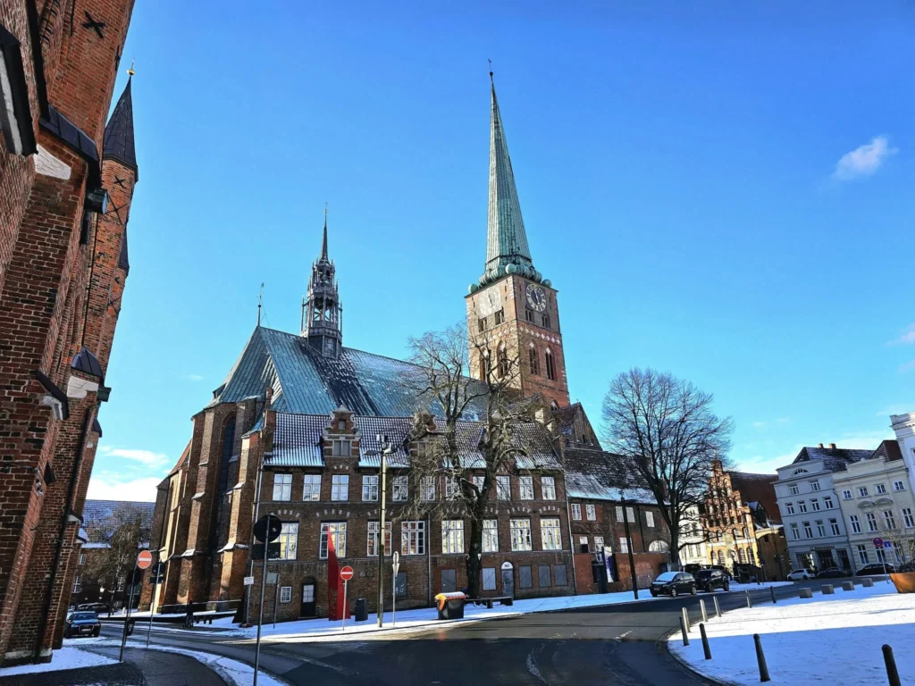 Cruising with Danny and Peter, MSC Cruises, MSC Preziosa, Hamburg, Germany, Lubeck City Tour showcasing the Holsten Gate, a historic medieval landmark with iconic round towers; St. Mary’s Church, known for its Gothic architecture and the world’s largest mechanical organ; charming cobblestone streets and UNESCO Heritage sites of Lubeck, reflecting its Hanseatic League history; traditional German lunch featuring bratwurst, sauerkraut, pretzels, and Lubeck’s famous marzipan, offering a taste of the city’s cultural and culinary heritage.