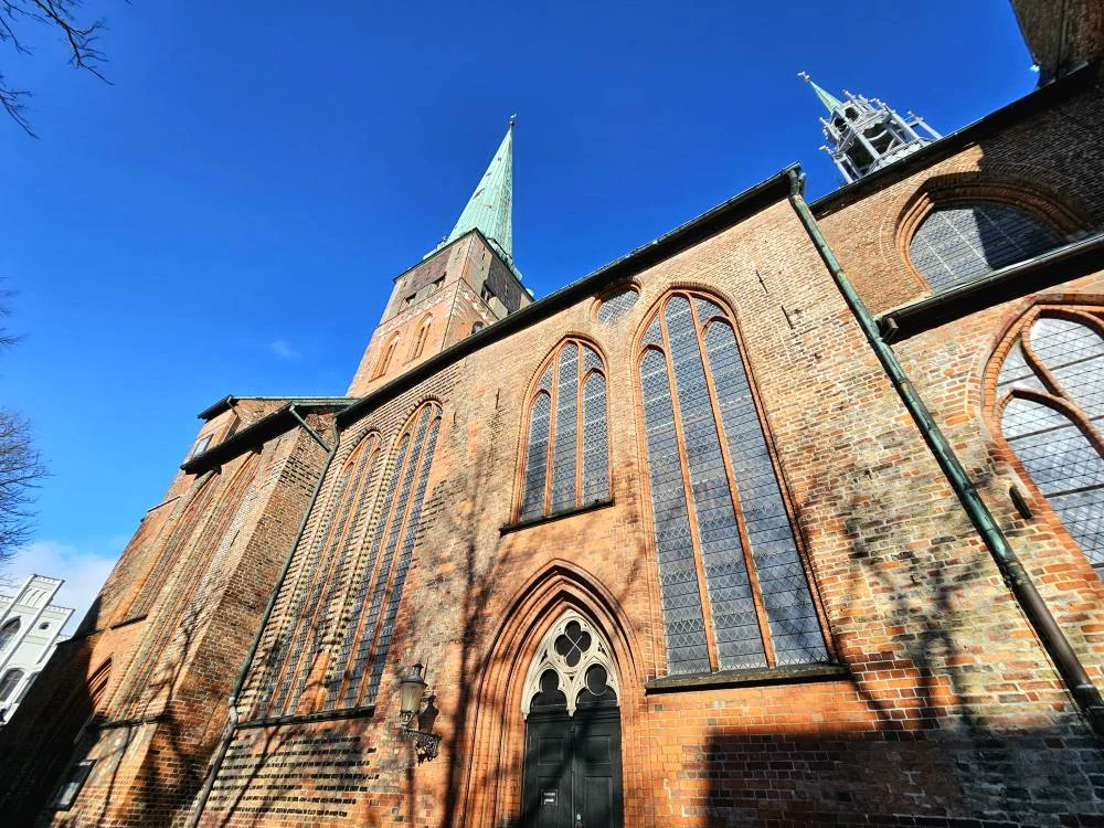 Cruising with Danny and Peter, MSC Cruises, MSC Preziosa, Hamburg, Germany, Lubeck City Tour showcasing the Holsten Gate, a historic medieval landmark with iconic round towers; St. Mary’s Church, known for its Gothic architecture and the world’s largest mechanical organ; charming cobblestone streets and UNESCO Heritage sites of Lubeck, reflecting its Hanseatic League history; traditional German lunch featuring bratwurst, sauerkraut, pretzels, and Lubeck’s famous marzipan, offering a taste of the city’s cultural and culinary heritage.