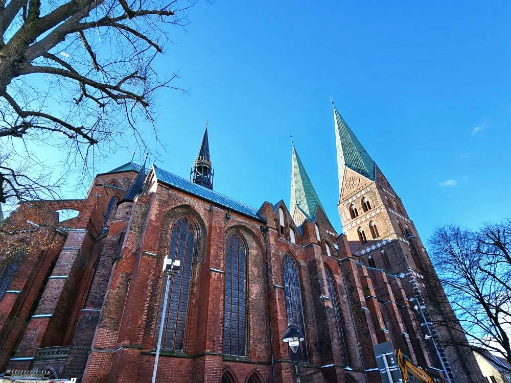 Cruising with Danny and Peter, MSC Cruises, MSC Preziosa, Hamburg, Germany, Lubeck City Tour showcasing the Holsten Gate, a historic medieval landmark with iconic round towers; St. Mary’s Church, known for its Gothic architecture and the world’s largest mechanical organ; charming cobblestone streets and UNESCO Heritage sites of Lubeck, reflecting its Hanseatic League history; traditional German lunch featuring bratwurst, sauerkraut, pretzels, and Lubeck’s famous marzipan, offering a taste of the city’s cultural and culinary heritage.