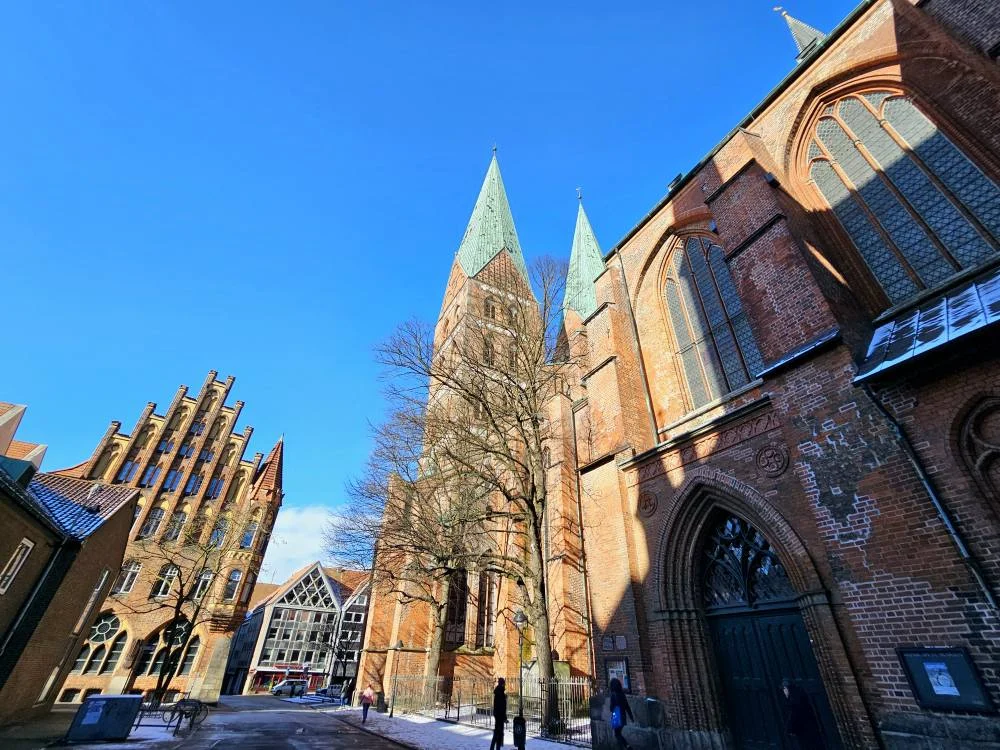 Cruising with Danny and Peter, MSC Cruises, MSC Preziosa, Hamburg, Germany, Lubeck City Tour showcasing the Holsten Gate, a historic medieval landmark with iconic round towers; St. Mary’s Church, known for its Gothic architecture and the world’s largest mechanical organ; charming cobblestone streets and UNESCO Heritage sites of Lubeck, reflecting its Hanseatic League history; traditional German lunch featuring bratwurst, sauerkraut, pretzels, and Lubeck’s famous marzipan, offering a taste of the city’s cultural and culinary heritage.