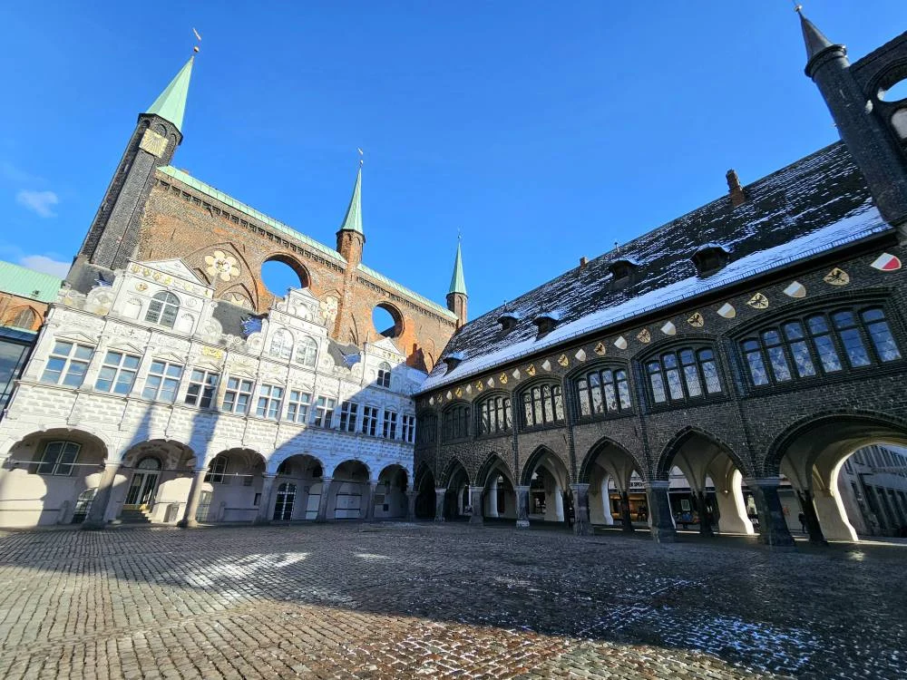 Cruising with Danny and Peter, MSC Cruises, MSC Preziosa, Hamburg, Germany, Lubeck City Tour showcasing the Holsten Gate, a historic medieval landmark with iconic round towers; St. Mary’s Church, known for its Gothic architecture and the world’s largest mechanical organ; charming cobblestone streets and UNESCO Heritage sites of Lubeck, reflecting its Hanseatic League history; traditional German lunch featuring bratwurst, sauerkraut, pretzels, and Lubeck’s famous marzipan, offering a taste of the city’s cultural and culinary heritage.