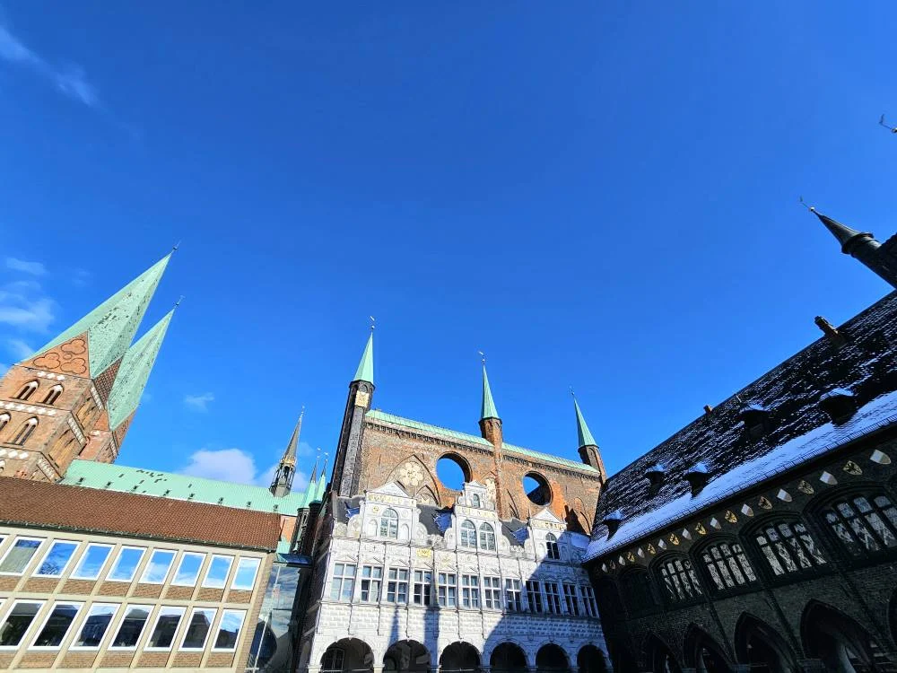 Cruising with Danny and Peter, MSC Cruises, MSC Preziosa, Hamburg, Germany, Lubeck City Tour showcasing the Holsten Gate, a historic medieval landmark with iconic round towers; St. Mary’s Church, known for its Gothic architecture and the world’s largest mechanical organ; charming cobblestone streets and UNESCO Heritage sites of Lubeck, reflecting its Hanseatic League history; traditional German lunch featuring bratwurst, sauerkraut, pretzels, and Lubeck’s famous marzipan, offering a taste of the city’s cultural and culinary heritage.