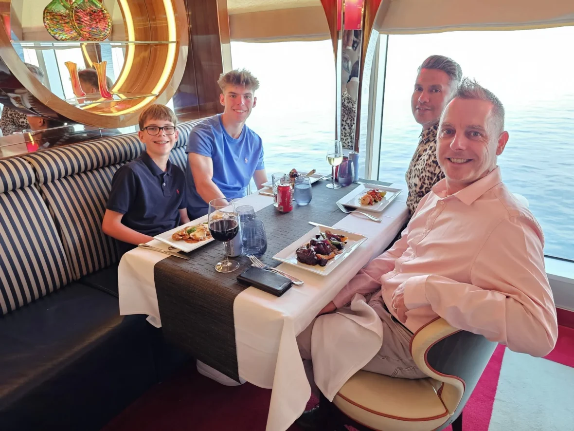 Cruising with Danny and Peter, Holland America Line, Nieuw Statendam, English Channel Sea Day | A montage of a sea day on Holland America’s Nieuw Statendam sailing the English Channel: calm waters meet Dover’s distant white cliffs from a balcony; Sven and Liam play pickleball on a sunlit deck with cheering crowds and a blue sea backdrop; vibrant cakes—chocolate, fruit, and cream-topped—fill the Lido Market as crew serve slices; a candlelit Canaletto table holds Italian dishes in a cozy, rustic dining room.