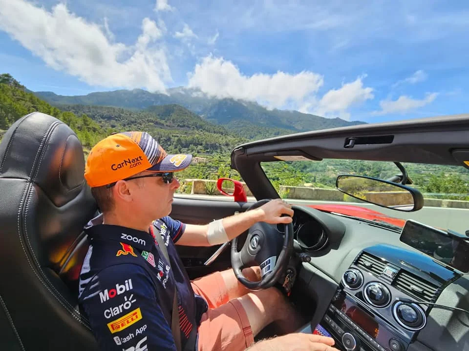 Cruising with Danny and Peter, Holland America Line, Nieuw Statendam, Palma de Mallorca, Spain | Scenic coastal drive in Mallorca during the Palma de Mallorca Sunset Tour, featuring rugged cliffs and azure waters. Historic Palma Cathedral with Gothic architecture is also highlighted. The luxurious seafood feast aboard MS Nieuw Statendam includes lobster, shrimp, and crab, complemented by a stunning Mediterranean sunset with pink and gold hues in the sky.