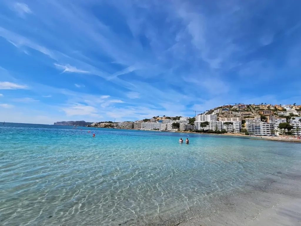 Cruising with Danny and Peter, Holland America Line, Nieuw Statendam, Palma de Mallorca, Spain | Scenic coastal drive in Mallorca during the Palma de Mallorca Sunset Tour, featuring rugged cliffs and azure waters. Historic Palma Cathedral with Gothic architecture is also highlighted. The luxurious seafood feast aboard MS Nieuw Statendam includes lobster, shrimp, and crab, complemented by a stunning Mediterranean sunset with pink and gold hues in the sky.