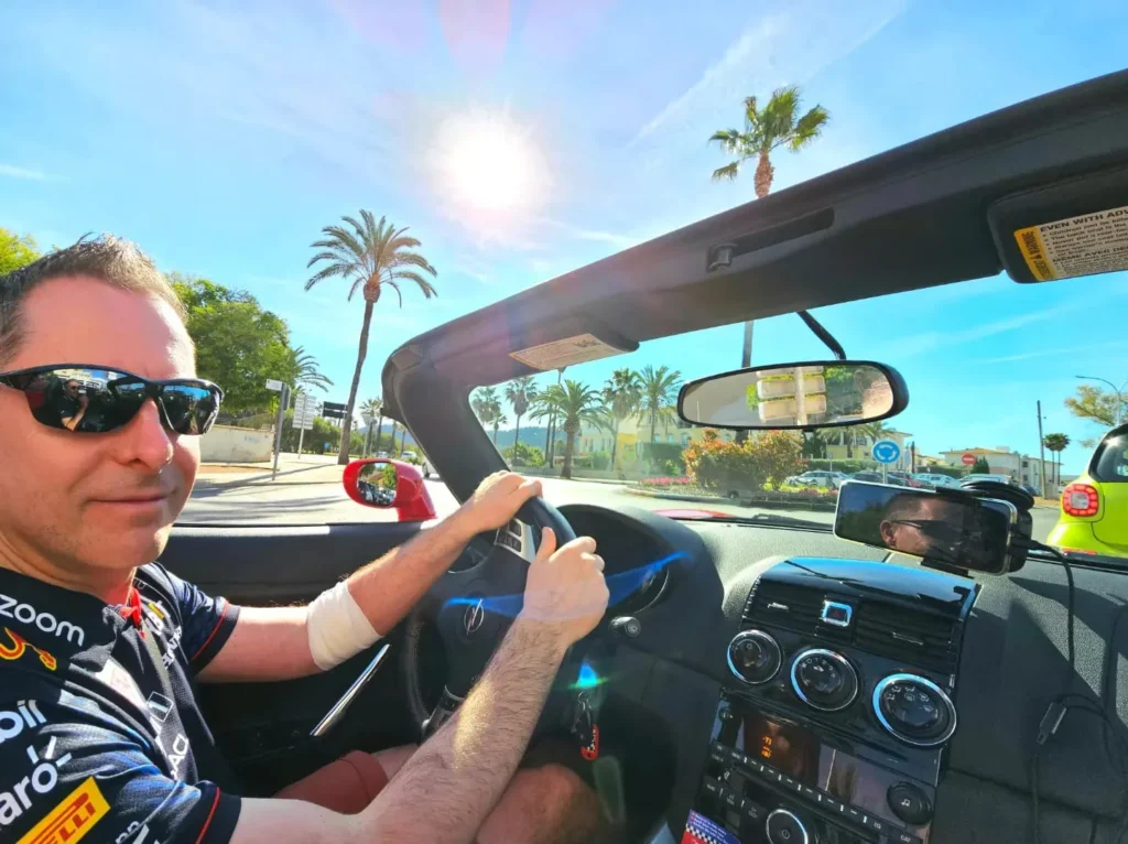 Cruising with Danny and Peter, Holland America Line, Nieuw Statendam, Palma de Mallorca, Spain | Scenic coastal drive in Mallorca during the Palma de Mallorca Sunset Tour, featuring rugged cliffs and azure waters. Historic Palma Cathedral with Gothic architecture is also highlighted. The luxurious seafood feast aboard MS Nieuw Statendam includes lobster, shrimp, and crab, complemented by a stunning Mediterranean sunset with pink and gold hues in the sky.