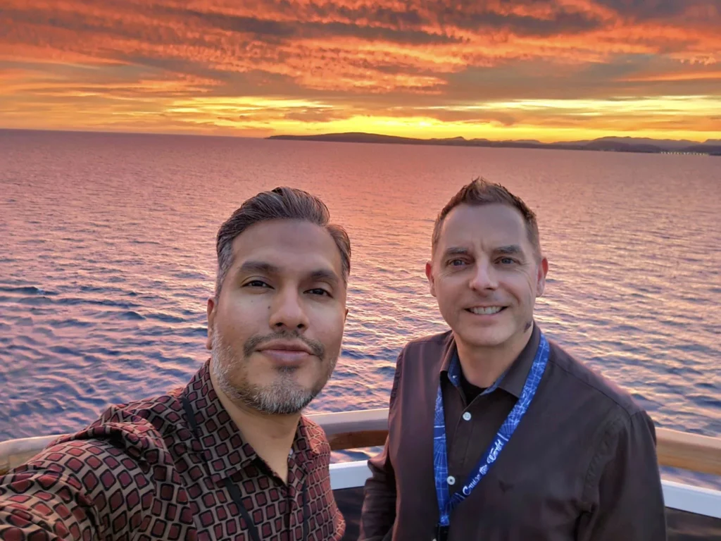 Cruising with Danny and Peter, Holland America Line, Nieuw Statendam, Palma de Mallorca, Spain | Scenic coastal drive in Mallorca during the Palma de Mallorca Sunset Tour, featuring rugged cliffs and azure waters. Historic Palma Cathedral with Gothic architecture is also highlighted. The luxurious seafood feast aboard MS Nieuw Statendam includes lobster, shrimp, and crab, complemented by a stunning Mediterranean sunset with pink and gold hues in the sky.