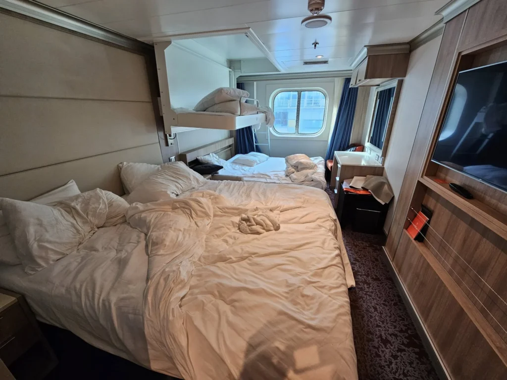 Cruising with Danny and Peter, Holland America Line, Nieuw Statendam, Rotterdam, The Netherlands, Canary Islands Adventure | A vibrant collage captures a family’s adventure on Holland America’s Nieuw Statendam during the Canary Island Enchantment cruise. The journey begins in Rotterdam, Netherlands, with the sleek ship docked against the city’s modern skyline, featuring the Erasmus Bridge. Onboard, the elegant atrium glows with Dutch-inspired decor, while the cozy Oceanview Family Cabin offers serene ocean views. The Lido Pool sparkles under the sun, and the Crow’s Nest provides panoramic vistas. In Agadir, Morocco, vibrant Souk El Had stalls overflow with colorful spices and crafts, and camel rides evoke Berber traditions. Lanzarote’s Cueva de los Verdes showcases dramatic lava tube formations, while Jameos del Agua features a surreal volcanic cave with a turquoise lake. Tenerife’s Anaga Rural Park displays misty laurel forests, and Playa de las Teresitas glows with golden sands. In Funchal, Madeira, a trike tour winds through banana fields, with Cabo Girão’s glass skywalk offering stunning cliff views. Porto’s rainy Ribeira District shines with colorful buildings and azulejo tiles at São Bento Station. In London, a black cab tour passes the iconic Tower Bridge and Buckingham Palace. The cruise ends with a serene sail-away past Dover’s White Cliffs, followed by a heartfelt family reunion in Rotterdam’s Zalmhaventoren apartment, with the city’s skyline in the background.