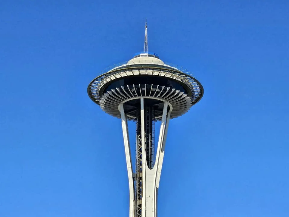 Cruising with Danny and Peter, Holland America Line, Westerdam, Seattle, Washington, United States, Day Trip Arctic Cruise | A vibrant collage capturing a day in Seattle, showcasing Lake Union’s serene waters reflecting the misty skyline with houseboats and kayakers, the towering Space Needle offering panoramic views of Puget Sound and Mount Rainier, and Chihuly Garden and Glass’s colorful glass sculptures blending with lush greenery. Pike Place Market buzzes with vendors tossing salmon and stalls brimming with flowers and artisanal goods under the iconic red sign. A cozy table at Villa Escondida displays tacos al pastor and enchiladas in a warm, mural-lined setting. The Seattle Great Wheel rises above Elliott Bay’s sparkling waterfront, while the Washington Park Arboretum’s tranquil paths feature blooming rhododendrons and a heron by a pond. The Japanese Garden’s koi pond, curved bridge, and stone lanterns create a Zen oasis, all set against Seattle’s dynamic blend of urban and natural beauty.