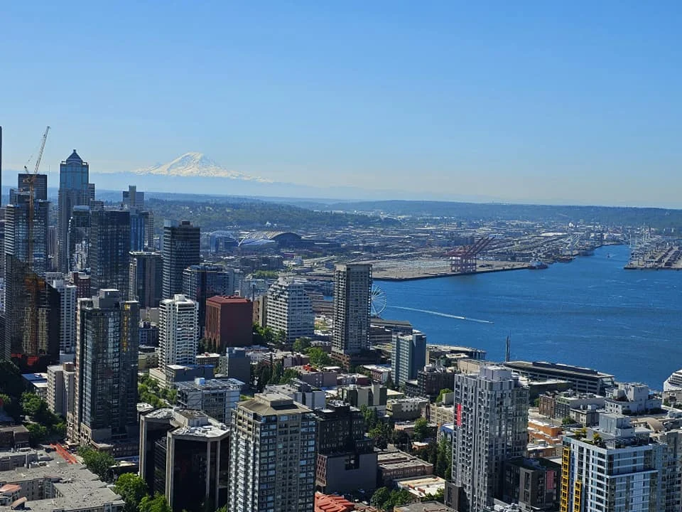 Cruising with Danny and Peter, Holland America Line, Westerdam, Seattle, Washington, United States, Day Trip Arctic Cruise | A vibrant collage capturing a day in Seattle, showcasing Lake Union’s serene waters reflecting the misty skyline with houseboats and kayakers, the towering Space Needle offering panoramic views of Puget Sound and Mount Rainier, and Chihuly Garden and Glass’s colorful glass sculptures blending with lush greenery. Pike Place Market buzzes with vendors tossing salmon and stalls brimming with flowers and artisanal goods under the iconic red sign. A cozy table at Villa Escondida displays tacos al pastor and enchiladas in a warm, mural-lined setting. The Seattle Great Wheel rises above Elliott Bay’s sparkling waterfront, while the Washington Park Arboretum’s tranquil paths feature blooming rhododendrons and a heron by a pond. The Japanese Garden’s koi pond, curved bridge, and stone lanterns create a Zen oasis, all set against Seattle’s dynamic blend of urban and natural beauty.
